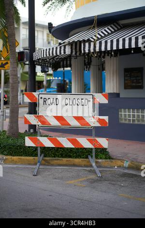 Route fermée panneau devant un bâtiment avec auvent rayé noir et blanc. Miami, Floride, États-Unis Banque D'Images