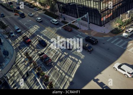 Vue aérienne d'un carrefour urbain animé avec des voitures et des ombres d'un bâtiment en verre. Miami, Floride, États-Unis Banque D'Images