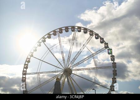Grande roue contre un ciel nuageux avec la lumière du soleil brille à travers. Bruxelles, Belgique Banque D'Images