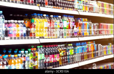 Bouteilles et canettes de boissons gazeuses sur les étagères des magasins, y compris les marques mondiales Coca Cola, Sprite, Dr Pepper, Lucozade, Relentless et Fanta. Boissons gazeuses. Banque D'Images