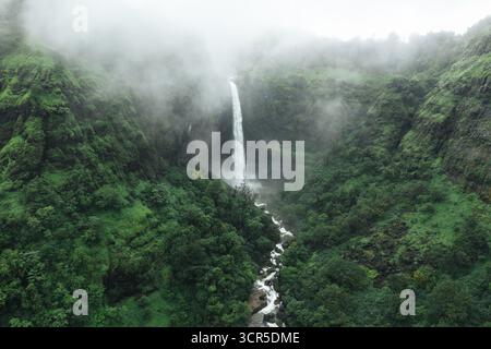 Vue aérienne d'une cascade de Kumbhe plongeant à travers des collines verdoyantes entourées de brume, une symphonie de la puissance et de la sérénité de la nature, Mangaon, Maha Banque D'Images