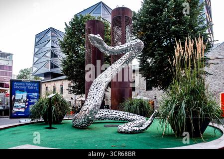 Sculpture moderne en miroir de serpent dans le quartier Rotermann, Tallinn, Estonie, mêlant art contemporain avec architecture industrielle historique et urbaine Banque D'Images