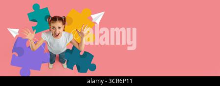Enfant appréciant l'apprentissage créatif avec des puzzles colorés et des avions de papier dans le cadre de l'école Banque D'Images