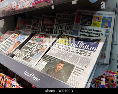 Londres, Royaume-Uni - 26 septembre 2025 : un kiosque à journaux très fréquenté avec des pages d'accueil du Guardian et d'autres journaux, présentant le journalisme imprimé et les publications quotidiennes. Banque D'Images