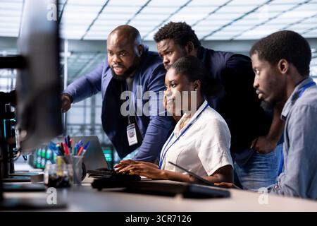 Équipe d'ingénieurs reconfigurant le parc de serveurs pour l'optimiser en fonction des besoins de traitement des données des clients. Collaboration entre collègues pour garantir le bon fonctionnement de l'équipement du centre de données Banque D'Images