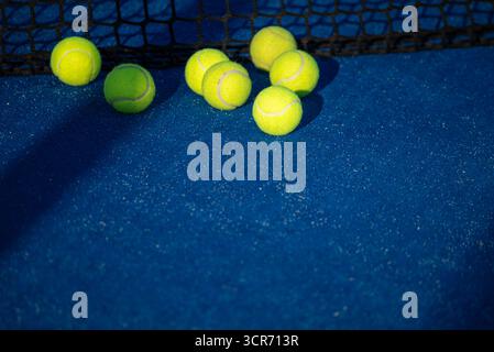 A balles de tennis jaunes sur un court bleu le concept d'un fond sportif Banque D'Images