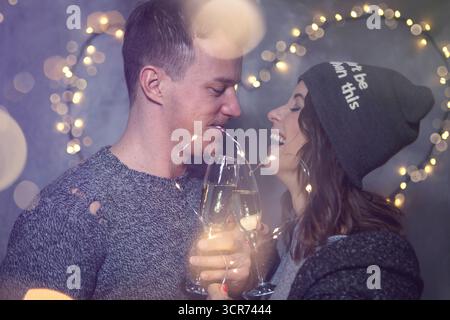 couplez des lunettes de claquage devant un cœur en fil de fer fait de lumières Banque D'Images