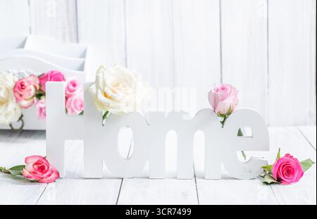 lettres en bois 'home' et fleurs de rose sur planches de bois blanc Banque D'Images