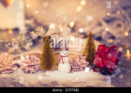 Arbres de Noël décoratifs, bonhomme de neige, cadeau et livre ouvert avec des pages pliées comme un cœur dans la décoration de Noël Banque D'Images