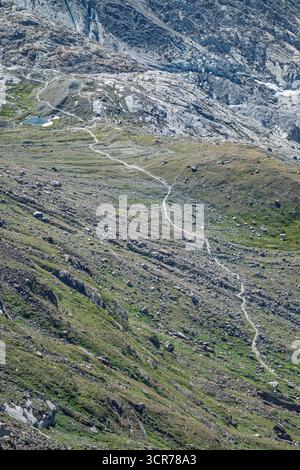 Un chemin sinueux serpente à travers le paysage alpin accidenté près du village suisse de Zermatt. Banque D'Images