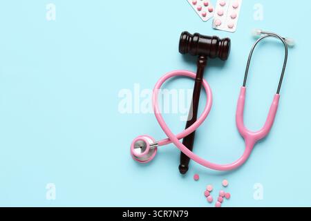 Juge Gavel, pilules et stéthoscope sur fond bleu. Concept de réforme des soins de santé Banque D'Images