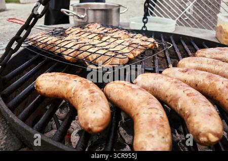 Griller avec une grille de hot-dogs dessus. Les hot-dogs sont sur le gril et sont en cours de cuisson Banque D'Images