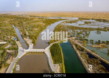(250930) -- YULI, 30 septembre 2025 (Xinhua) -- une photo de drone aérien prise le 20 septembre 2025 montre une vue de la rivière Tarim et d'un carrefour de dérivation des eaux de l'estuaire dans le comté de Yuli, préfecture autonome mongole de Bayingolin, région autonome ouïgoure du Xinjiang, au nord-ouest de la Chine. Le fleuve Tarim, qui longe le bord du bassin aride du Tarim, est le plus long fleuve intérieur de Chine, couvrant une zone de drainage de 1,02 millions de kilomètres carrés. Serpentant le long de la rive nord du désert de Taklimakan, la rivière nourrit environ 15 millions de mu (1 million d'hectares) de forêts populus euphratica flanquant Banque D'Images