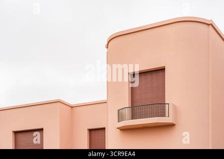 Détail architectural de la saisissante façade rose saumon avec des lignes courbes lisses, des volets fermés et un petit balcon de la Villa Serralves, Porto Banque D'Images
