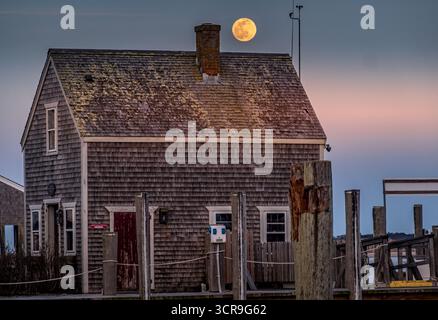 Vue aérienne du revêtement de bardeaux altérés d'un ancien bâtiment sous une pleine lune lumineuse, Nantucket, Massachusetts, États-Unis. Banque D'Images
