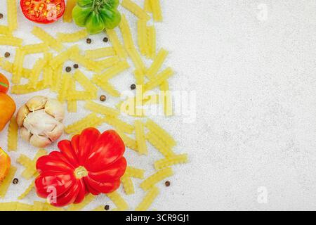 Pâtes crues mafalda Corta avec assortiment de tomates anciennes, ail, piment et épices. Concept de la ferme à la table, légumes maison sains, plat l Banque D'Images