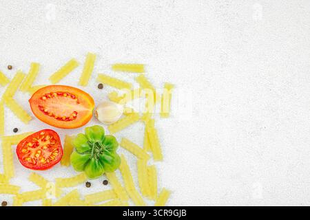 Pâtes crues mafalda Corta avec assortiment de tomates anciennes, ail, piment et épices. Concept de la ferme à la table, légumes maison sains, plat l Banque D'Images