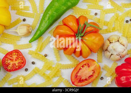 Pâtes crues mafalda Corta avec assortiment de tomates anciennes, ail, piment et épices. Concept de la ferme à la table, légumes maison sains, plat l Banque D'Images