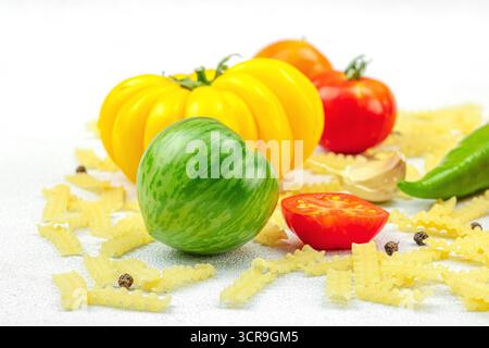 Pâtes crues mafalda Corta avec assortiment de tomates anciennes, ail, piment et épices. Concept de la ferme à la table, légumes maison sains, plat l Banque D'Images