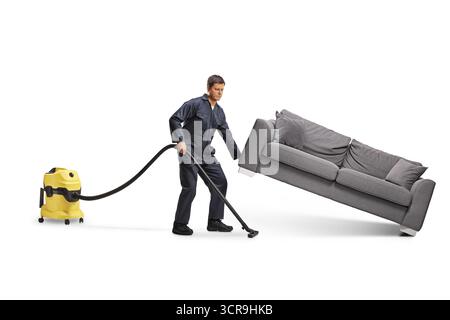 Aspirateur de service masculin utilisant un aspirateur sous un canapé isolé sur fond blanc Banque D'Images