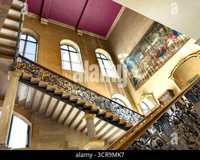Observez un escalier orné d'une balustrade en fer forgé menant au palier dans le château historique de Bowes avec de grandes fenêtres et une tapisserie spectaculaire du château Barnard Banque D'Images