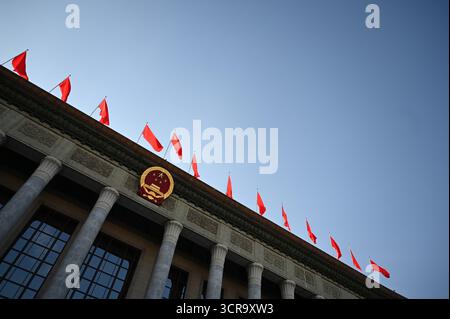 Pékin, Chine. 30 septembre 2025. L'emblème de la République populaire de Chine est arboré sur la Grande salle du peuple. La Chine a organisé une réception à la veille de la Fête nationale pour marquer la fondation de la République populaire de Chine en 1949. Crédit : Johannes Neudecker/dpa/Alamy Live News Banque D'Images
