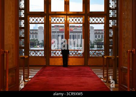 Pékin, Chine. 30 septembre 2025. Un gardien de sécurité se tient devant une porte d'entrée dans la Grande salle du peuple. La Chine a organisé une réception à la veille de la Fête nationale pour marquer la fondation de la République populaire de Chine en 1949. Crédit : Johannes Neudecker/dpa/Alamy Live News Banque D'Images