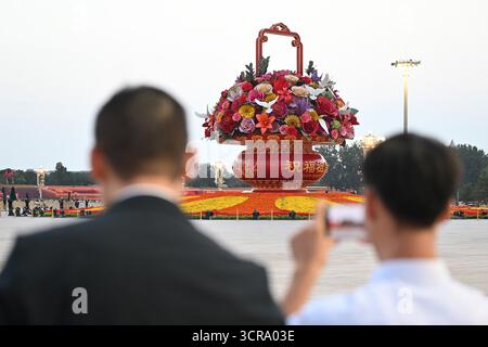 Pékin, Chine. 30 septembre 2025. Les gens regardent un arrangement floral sur la place Tiananmen. La Chine a organisé une réception à la veille de la Fête nationale pour marquer la fondation de la République populaire de Chine en 1949. Crédit : Johannes Neudecker/dpa/Alamy Live News Banque D'Images