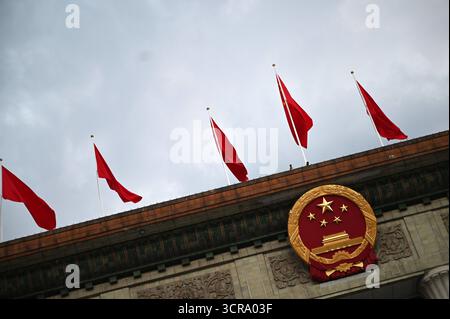 Pékin, Chine. 30 septembre 2025. L'emblème de la République populaire de Chine est arboré sur la Grande salle du peuple. La Chine a organisé une réception à la veille de la Fête nationale pour marquer la fondation de la République populaire de Chine en 1949. Crédit : Johannes Neudecker/dpa/Alamy Live News Banque D'Images