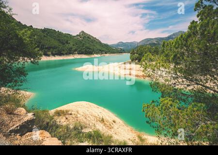Vue sur un lac de montagne par une journée ensoleillée en été. Réservoir de Guadalest dans la vallée de Guadalest, Alicante, Espagne, Europe Banque D'Images
