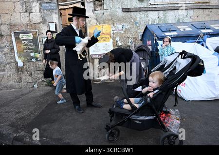 Jérusalem, Israël. 30 septembre 2025. Une femme juive ultra-orthodoxe se penche alors que son mari tient un poulet tout en exécutant l’ancien rituel juif de Kapparot à Mea Shearim à Jérusalem, le mardi 30 septembre 2025. Le rituel Kapparot est exécuté avant Yom Kippour, le jour des Expiations, tandis que la personne prie en balançant un poulet sur sa tête, ce qui transfère symboliquement les péchés de l'année passée au poulet. Yom Kippour est le jour le plus Saint de l'année juive et commence au coucher du soleil le 1er octobre. Photo de Debbie Hill/ crédit : UPI/Alamy Live News Banque D'Images