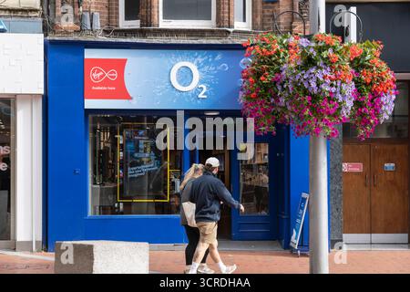 Des gens passant devant un magasin O2 sur Broad Street à Reading, au Royaume-Uni. La société de téléphonie mobile et haut débit est VMED O2 UK Limited, opérant sous le nom de Virgin Media O2 Banque D'Images
