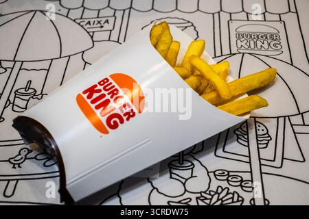 Marilia, SP, Brésil, 29 mai 2025. Frites Burger King renversées dans un sac de papier blanc sur fond de napperon illustré, mettant en valeur le son de restauration rapide Banque D'Images