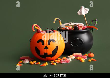 Chaudrons avec des bonbons pour Halloween sur fond vert, gros plan Banque D'Images