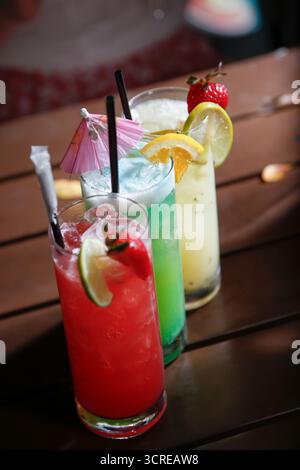 Une vue sur une rangée de cocktails colorés sur une table de restaurant. Banque D'Images