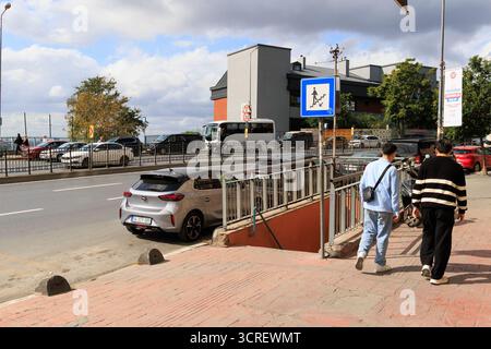 un métro avec un panneau le montre et les gens qui le traversent et la circulation près du métro à istanbul Banque D'Images