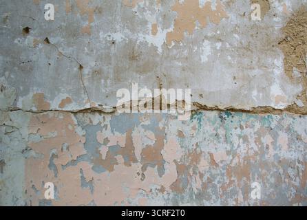Vieux mur altéré avec de la peinture écaillée, des briques apparentes et un interrupteur rouge vintage. Textures rustiques et détails de décomposition créent un industriel, urbain Banque D'Images