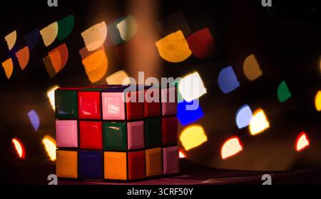 Un Rubik's Cube avec l'arrière-plan d'un bokeh carré coloré Banque D'Images
