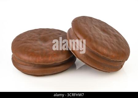 Deux biscuits au chocolat sont assis sur un fond blanc. Les biscuits sont gros et ronds, et ils semblent être des biscuits aux pépites de chocolat Banque D'Images