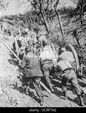 Les troupes italiennes de la première Guerre mondiale poussent un canon court de 155mm à travers un col de montagne rugueux, 1916. En l'absence de routes fiables, les unités d'artillerie comptent sur une main-d'œuvre pure pour déplacer des canons à travers le terrain alpin accidenté sous le feu ennemi. Publiée dans le miroir, cette photographie dramatique de temps de guerre met en évidence le coût humain du transport d’armes pendant la Grande Guerre, montrant des soldats qui s’efforcent ensemble de tirer la lourde pièce en position. Banque D'Images