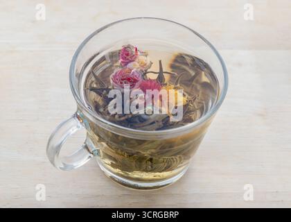 Thé florissant (également connu sous le nom de thé à fleurs ou thé artistique). est un type de thé cousu à la main fabriqué à partir de feuilles de thé séchées qui sont enroulées autour de comestibles séchés Banque D'Images