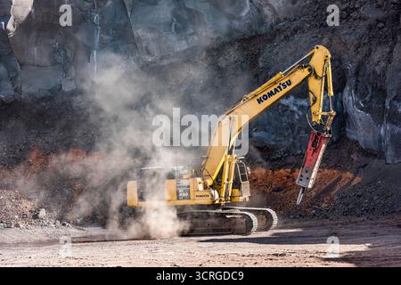 Une pelle sur chenilles KOMATSU PC490 LC équipée d’un marteau hydraulique (marteau à percussion) séparant la roche basaltique volcanique dans une carrière sur l’Etna Banque D'Images