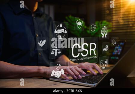 Concept de responsabilité sociale des entreprises (RSE). Personne utilisant un ordinateur portable avec des icônes RSE représentant des pratiques commerciales éthiques, la durabilité, la communauté Banque D'Images
