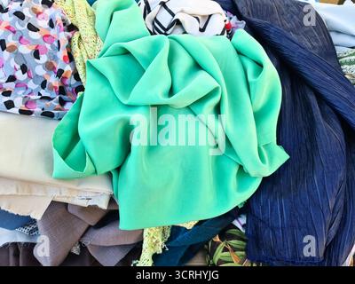 Tissus colorés assortis et textiles avec différents motifs et textures. Une pièce de tissu vert menthe est sur le dessus de la pile Banque D'Images