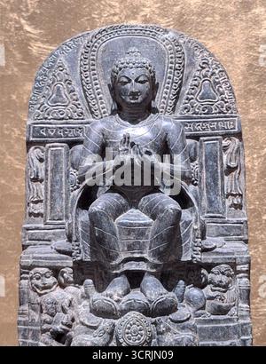 Gros plan vertical d'une ancienne statue bouddhiste représentant Bouddha prêchant sur un trône de lion, montrant le geste de Dharmacakra avec ses mains Banque D'Images