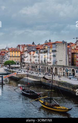 Les bateaux traditionnels Rabelo ont accosté sur le fleuve Douro en face des maisons historiques colorées du front de mer du district de Ribeira à Porto, au Portugal Banque D'Images