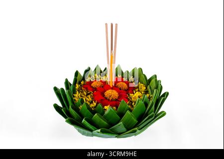 Feuille de banane Krathong qui ont 3 bâtons d'encens et la bougie décorent avec des fleurs rouges et jaunes pour Loy Krathong festival isolé sur papier blanc bac Banque D'Images