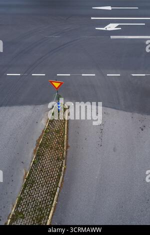 Vue de dessus d'une intersection avec un panneau de rendement et des marquages routiers. Banque D'Images