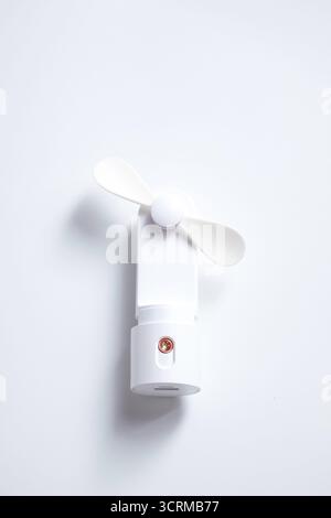 Mini ventilateur électrique avec poignée isolé sur fond blanc Banque D'Images