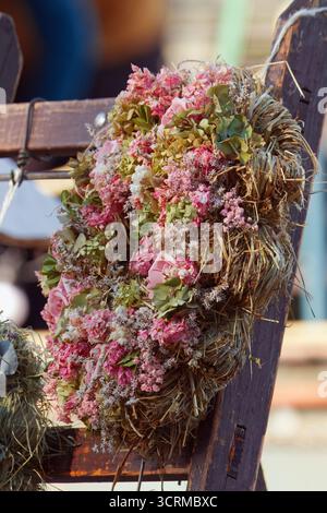 Gros plan d'une couronne florale faite à la main avec des roses roses et des fleurs séchées au marché fermier Naplavka à Prague. Banque D'Images